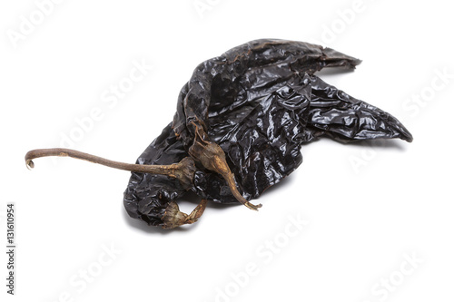 Dried black pasilla chili pepper isolated on white background. photo