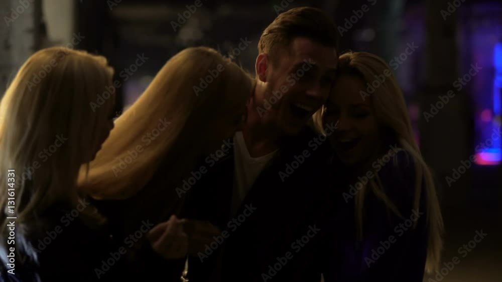 Three beautiful blond women flirting with man at night club, relaxation, hook-up Three beautiful blond women flirting with man at night club, relaxation, hook-up