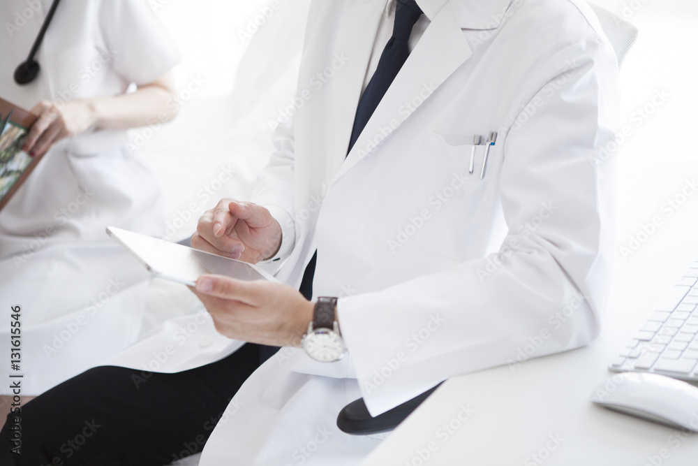 Male doctor is using electronic tablet Male doctor is using electronic tablet