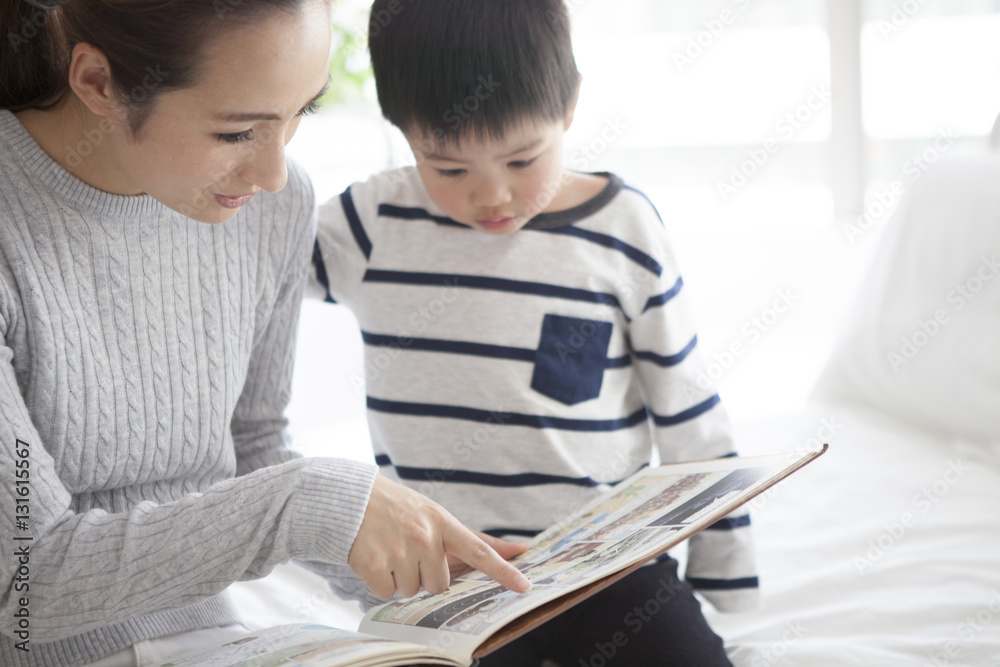 Mother and son are reading a picture book in my bedroom Mother and son are reading a picture book in my bedroom