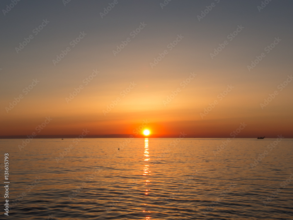 Fototapeta premium Fiery sunrise at Italian beach. Summer season. Emilia Romagna region. Adriatic sea. Italy