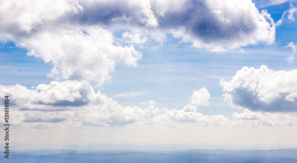 Over the Clouds. Dramatic sky view, misty mountain landscape below. Sun beams flow to land