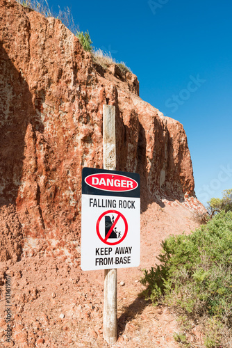 Danger warning sign Falling Rocks keep away from cliff base