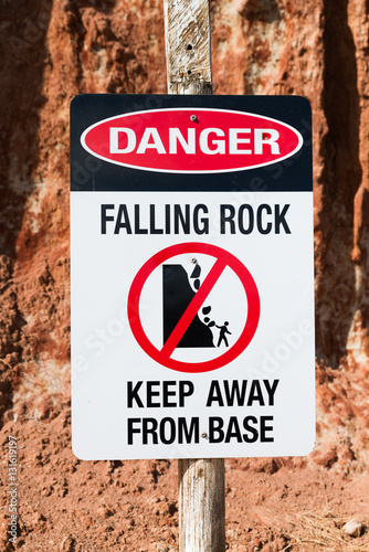 Danger warning sign Falling Rocks keep away from cliff base