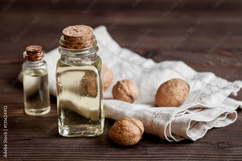 cosmetic and therapeutic walnut oil on dark wooden background cosmetic and therapeutic walnut oil on dark wooden background