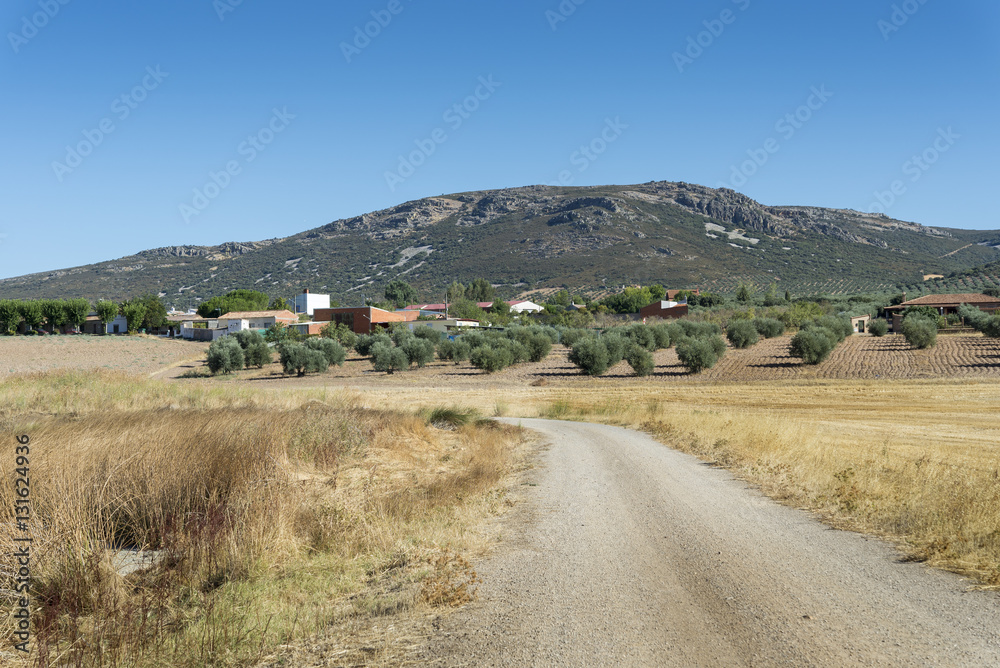 Small hamlet in an agricultural landscape in La Mancha, Ciudad Real Province, Spain. In the background can be seen the Toledo Mountains Small hamlet in an agricultural landscape in La Mancha, Ciudad Real Province, Spain. In the background can be seen the Toledo Mountains