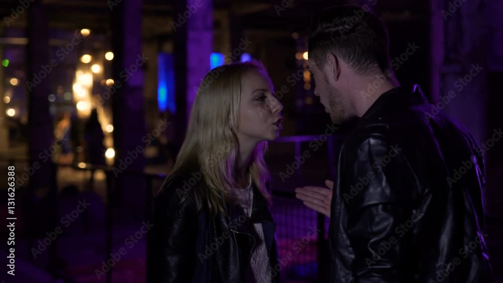 Jealous guy talking to girlfriend near night club, relationships, disagreement Jealous guy talking to girlfriend near night club, relationships, disagreement