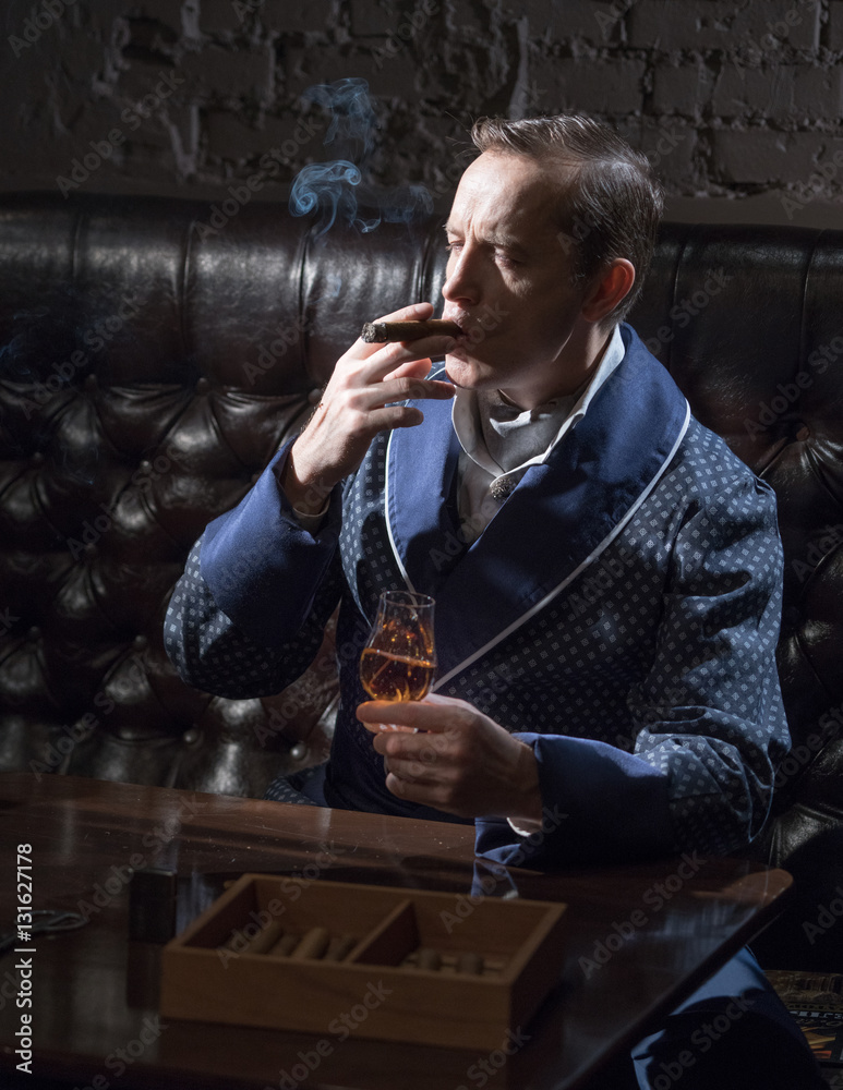 Man in an elegant robe smoking a cigar and drinking alcohol Stock Photo |  Adobe Stock