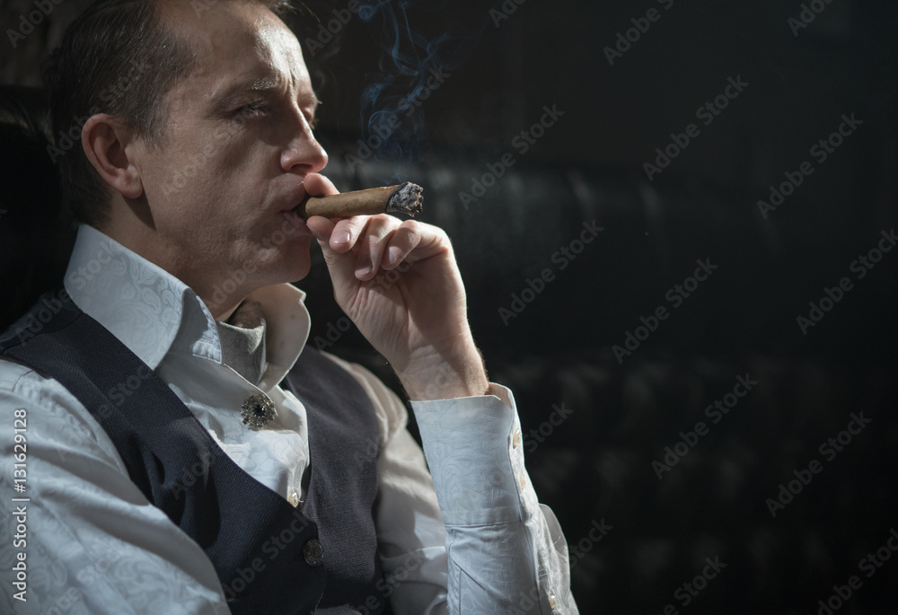 Man holding a cigar in his mouth StockFoto Adobe Stock