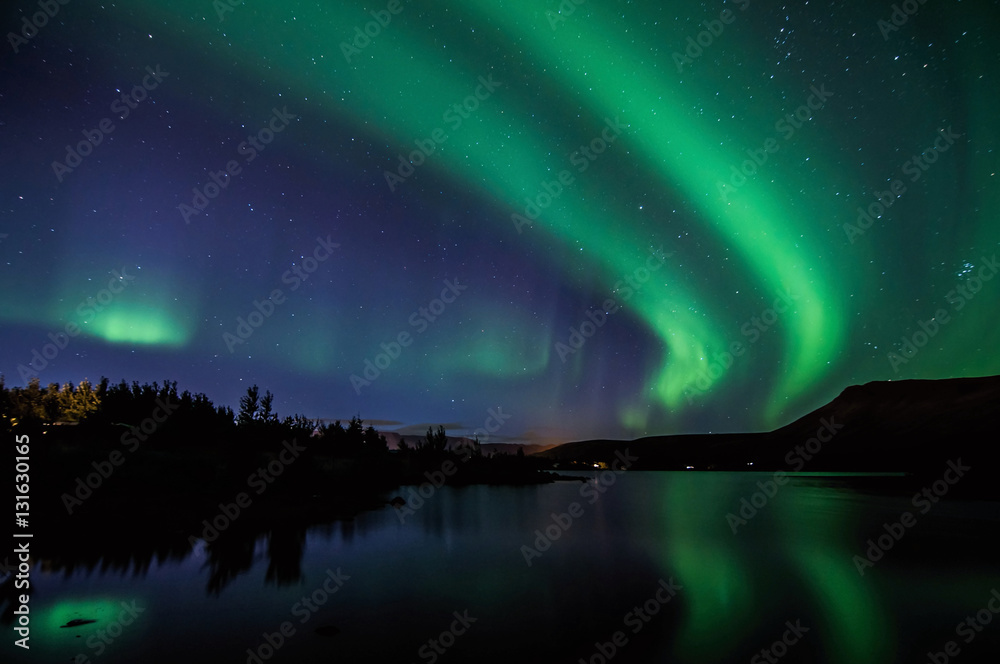 Northen lights (Aurora Borealis) in Iceland with mirroring on the lake