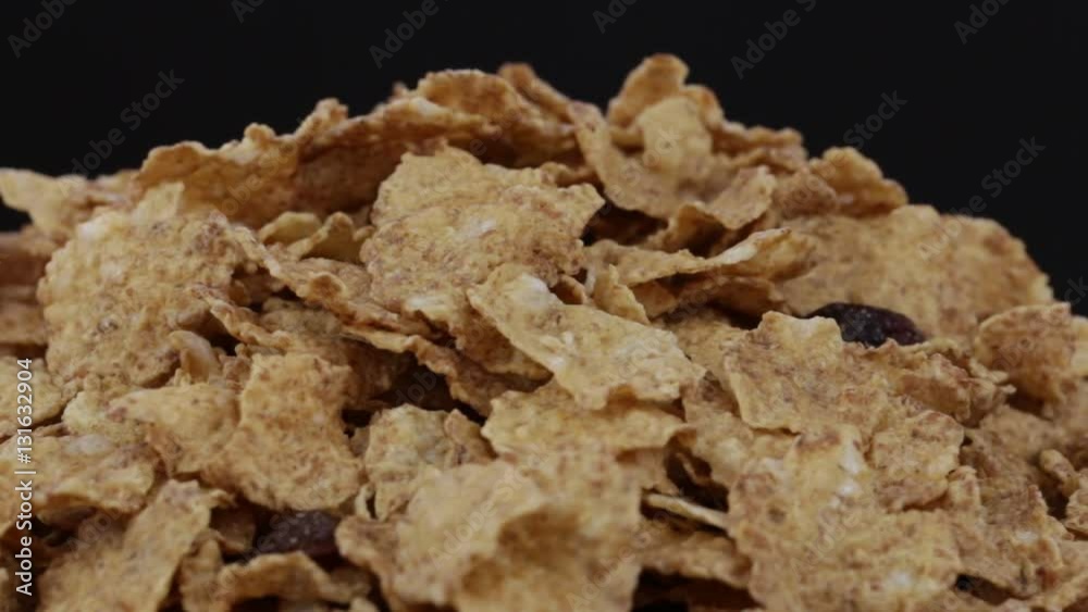 Granola cereal, nuts and raisins rotating . Crunchy tasty muesli food background close-up. Cereals and dried food mixed for breakfast Granola cereal, nuts and raisins rotating . Crunchy tasty muesli food background close-up. Cereals and dried food mixed for breakfast