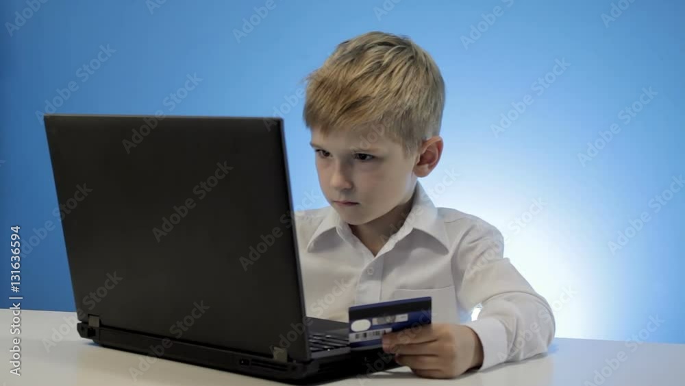 Cute little boy use laptop and credit card Cute little boy use laptop and credit card