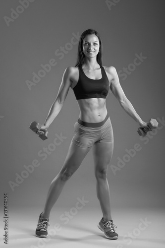 sporty muscular woman working out with dumbbells © zhagunov_a