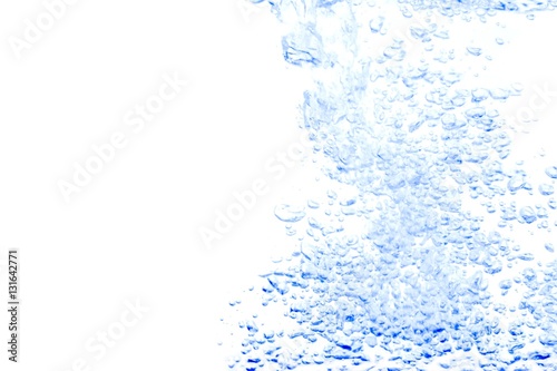 Water splash with bubbles of air, on the Blue background.