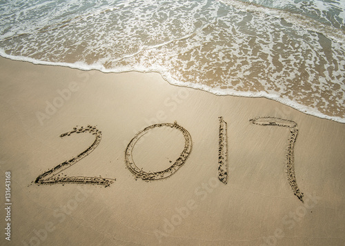 2017 written in sand write on tropical beach