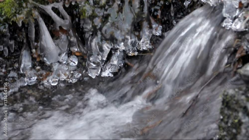 A small winter stream running, ambiente is frozen