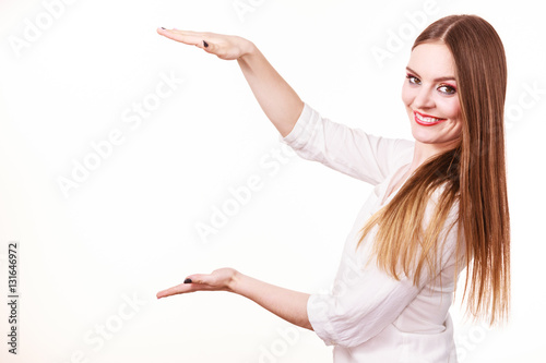 Woman uses hands to indicate area of frame, copy space for product