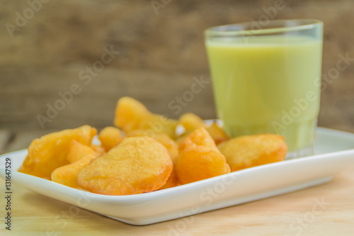фотографія green soybean milk and deep-fried doughstick on wood background