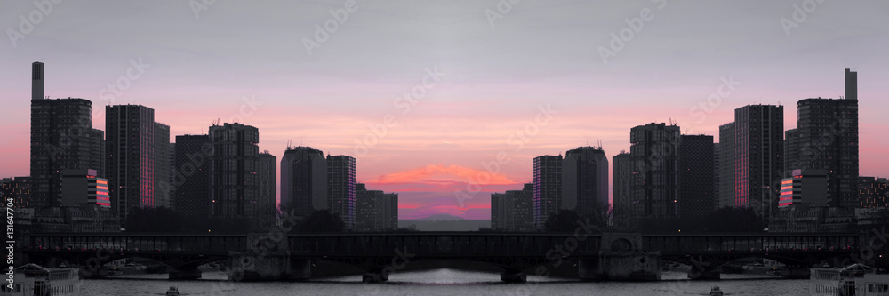 Cityscape with buildings, bridge, river and red sunset sky. Selective focus. Copy space. Toned image. Wide panoramic image.