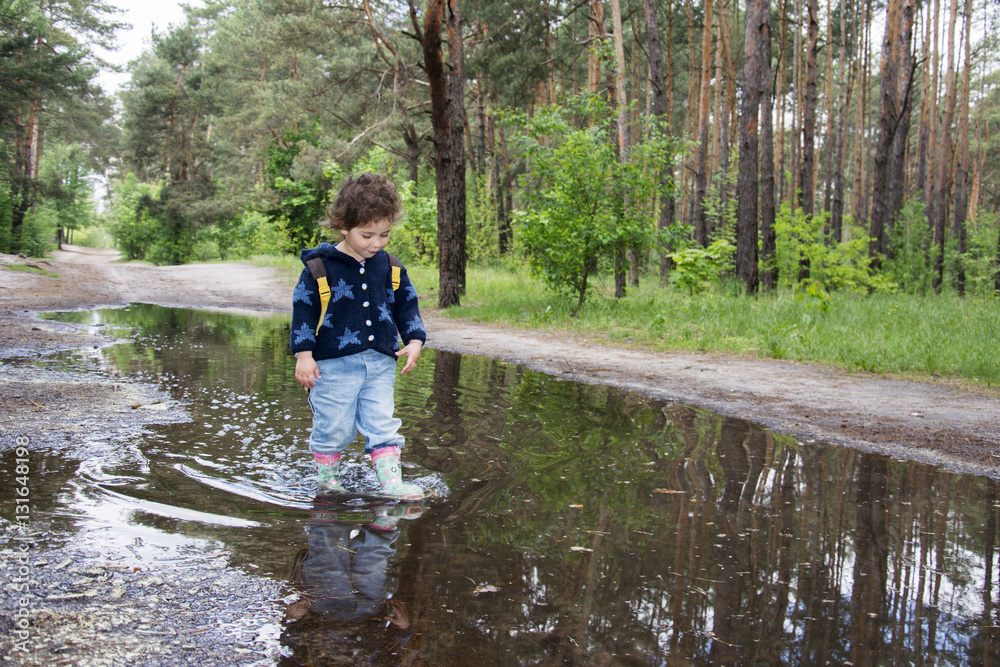 In the spring of funny little girl standing in a pool of rubber In the spring of funny little girl standing in a pool of rubber