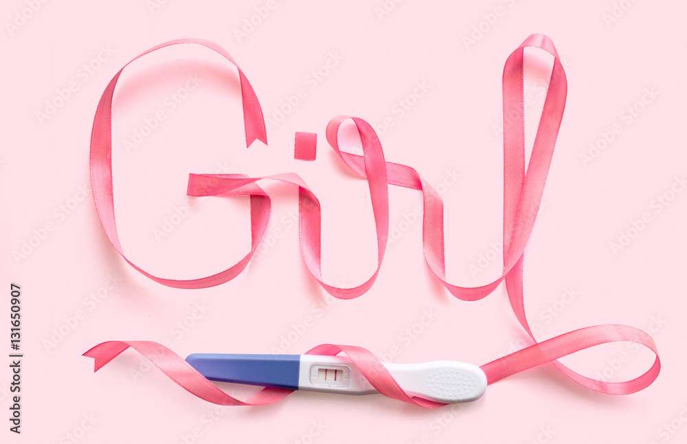 Word girl written gift ribbon pink. A positive pregnancy test. Pink background Word girl written gift ribbon pink. A positive pregnancy test. Pink background