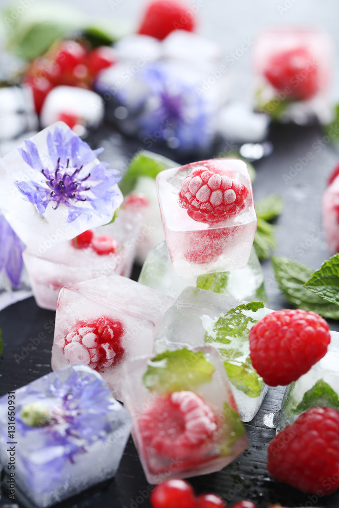 Ice cubes with raspberries and mint leaf on wooden table Ice cubes with raspberries and mint leaf on wooden table