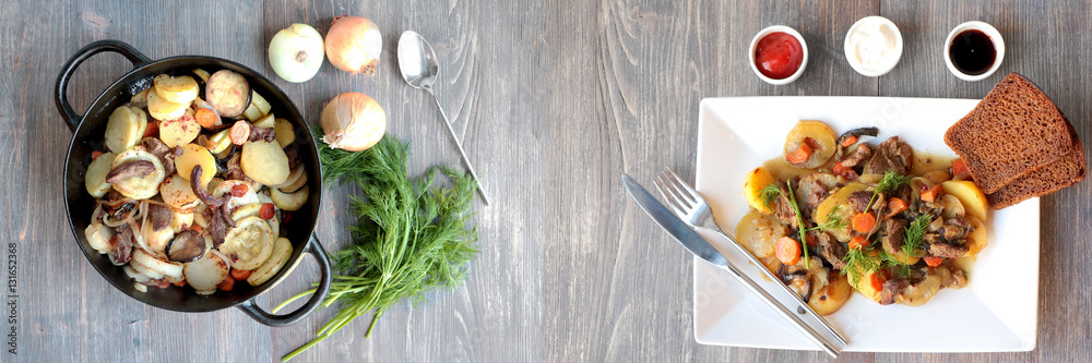 Fresh stew with herbs and sauces on wooden table. Wide panoramic image.