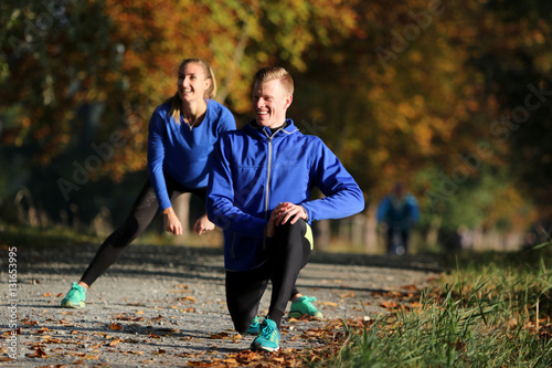 Junges Laufpaar beim Stretching photo