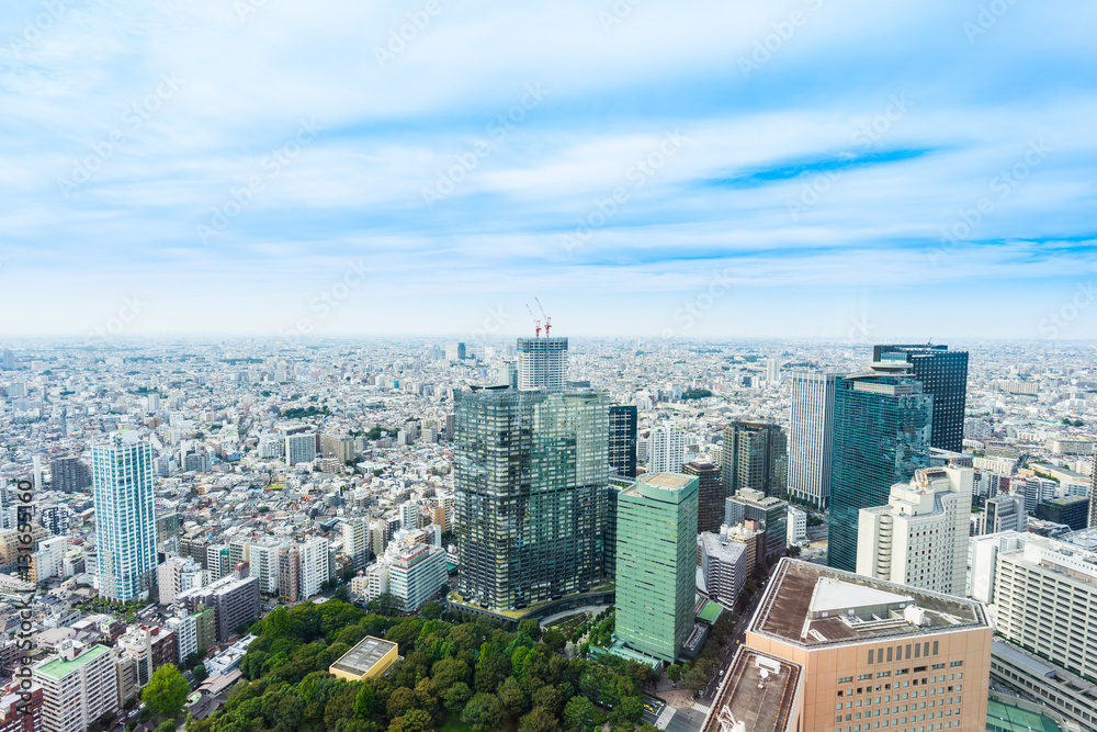 Fototapeta premium Business and culture concept - panoramic modern city skyline bird eye aerial view under dramatic sun and morning blue cloudy sky in Tokyo, Japan