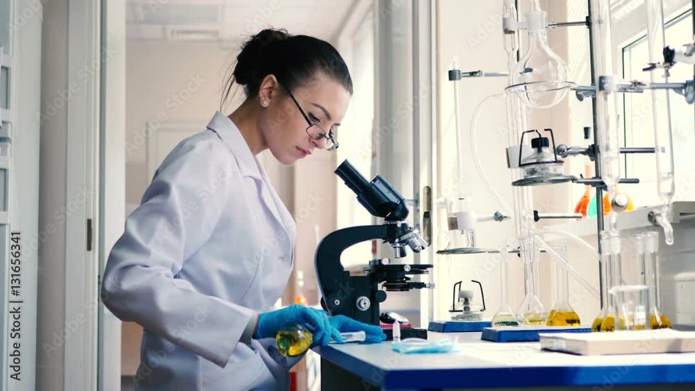 Lab worker pouring the solution on the glass.