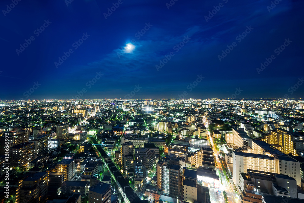 Business and culture concept for real estate and corporate construction - panoramic modern city skyline bird eye aerial night view under dramatic neon glow and beautiful dark blue sky in Tokyo, Japan