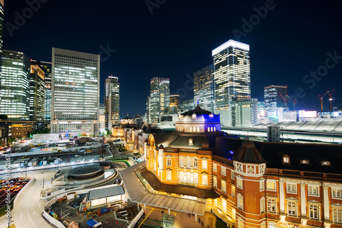 Asia Business concept for real estate and corporate construction - panoramic modern cityscape building bird eye aerial night view of Tokyo Station under neon light and dark blue sky in Tokyo, Japan © voyata