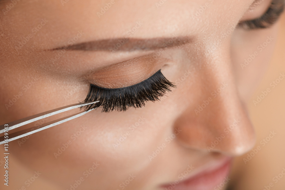 Beauty Makeup. Woman Applying Black False Eyelashes With Tweezer