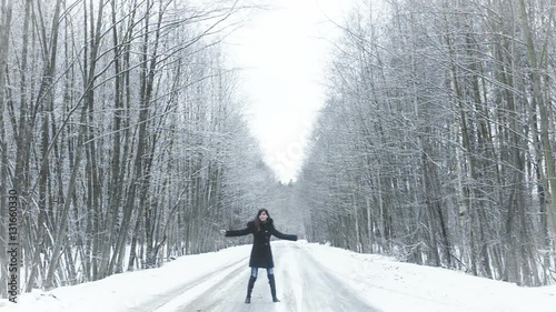 girl spinning on the road in the forest