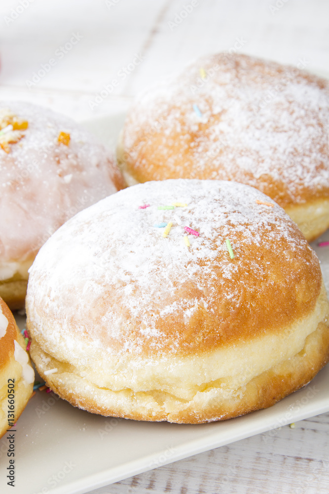 donuts with frosting and powdered sugar on a platter