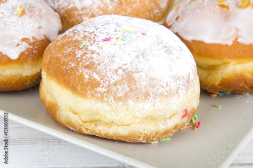 donuts with frosting and powdered sugar on a platter