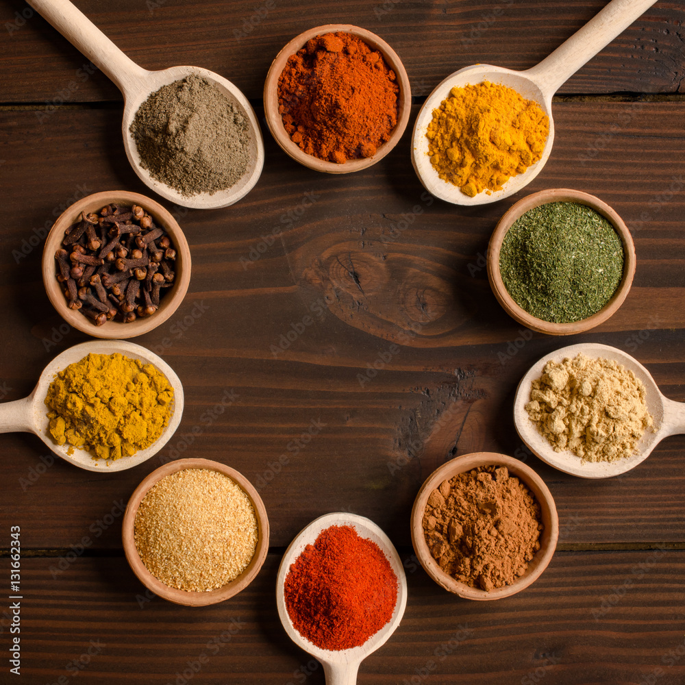 Different spices in bowls and mixing spoons  - Top view