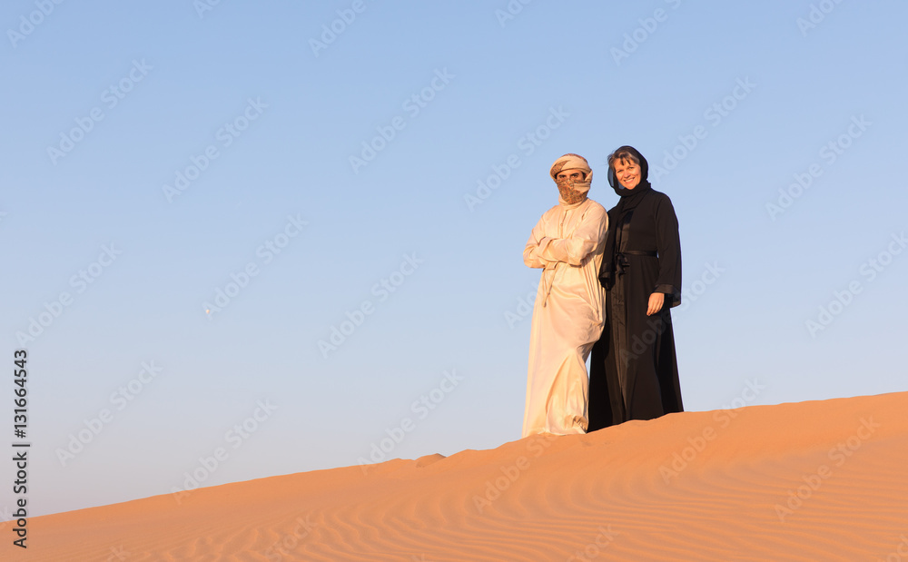 Couple dressed in traditional arabic dress in desert of Dubai, UAE. Couple dressed in traditional arabic dress in desert of Dubai, UAE.
