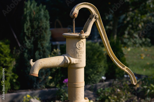 Hand water pump in the garden photo