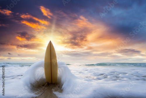 Surfboard on the beach at sunset