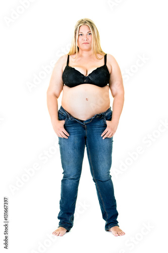 Overweight woman in a bra and unzipped jeans.