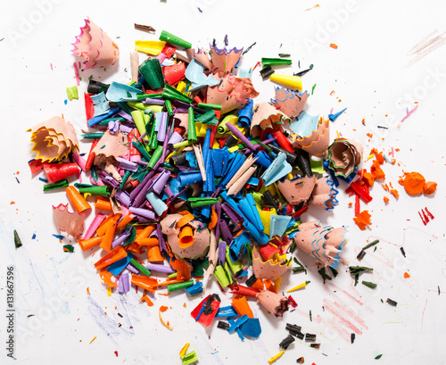 Colorful shavings obtained by sharpening colored pencils, mixed, and on the table. 