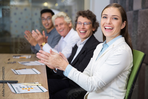 Cheerful business people clapping in boardroom
