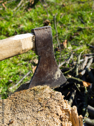 Old ax stuck in a wooden log