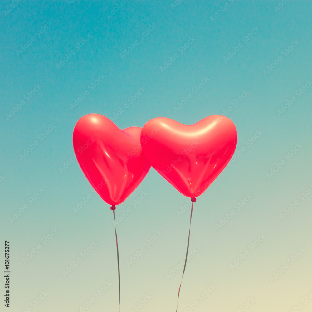 Two red heart shaped balloons in flight Two red heart shaped balloons in flight