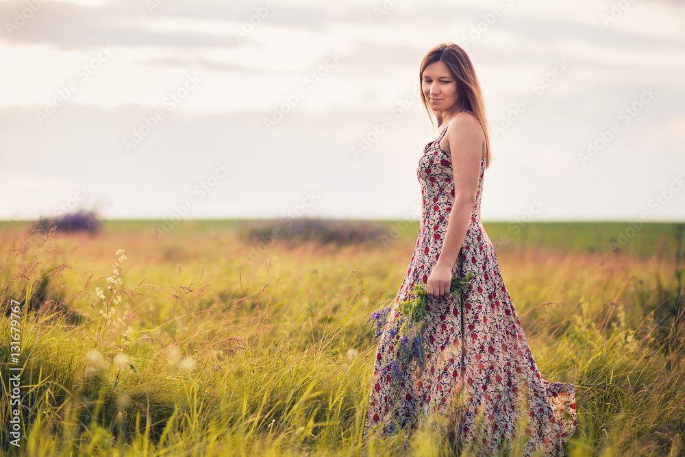 Obraz premium Girl with wild flowers in their hands