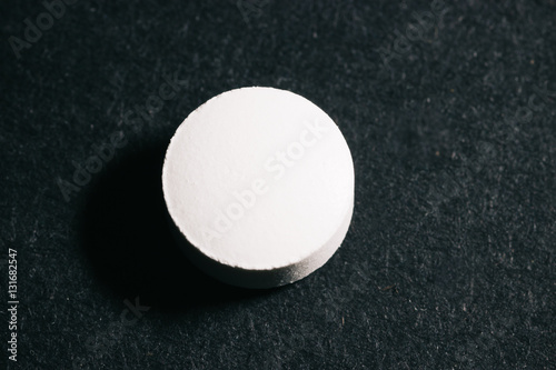 Pill isolated alone in under a spotlight