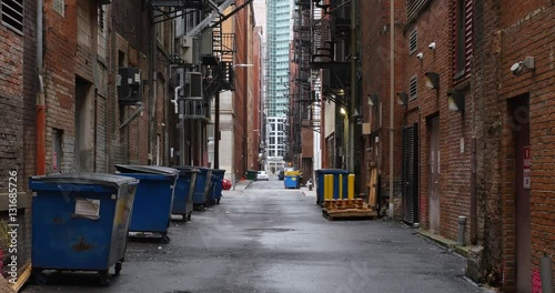 A daytime overcast establishing shot of an empty alley in a big city.	 	 photo