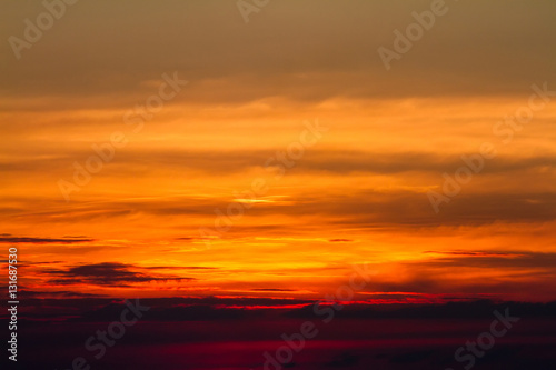 Sunset in clouds over red sunset sky background. © bubbers