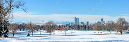 Winter at Denver City Park - A panoramic winter scene at a snow-covered city park, Downtown Denver, Colorado, USA.  Denver Skyline and snow-capped Mount Evans are rising high in the background. 